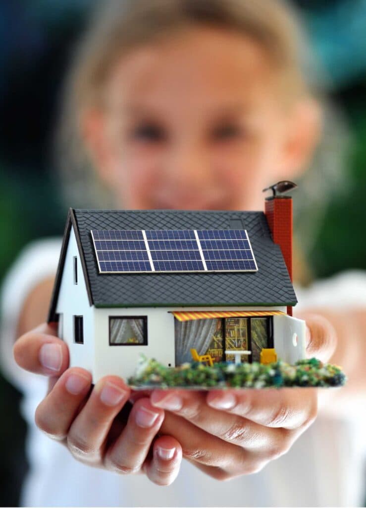 Kind hält Hausmodell mit Solaranlage — Zukunft der Energie