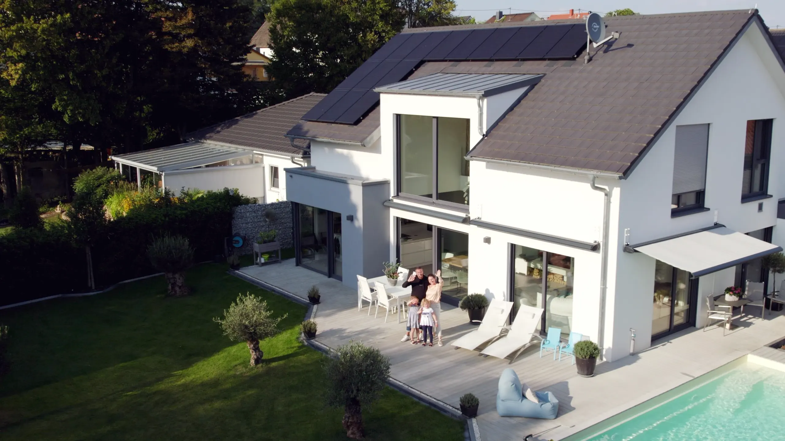 Modernes Einfamilienhaus mit Solaranlage — Familie auf der Terrasse